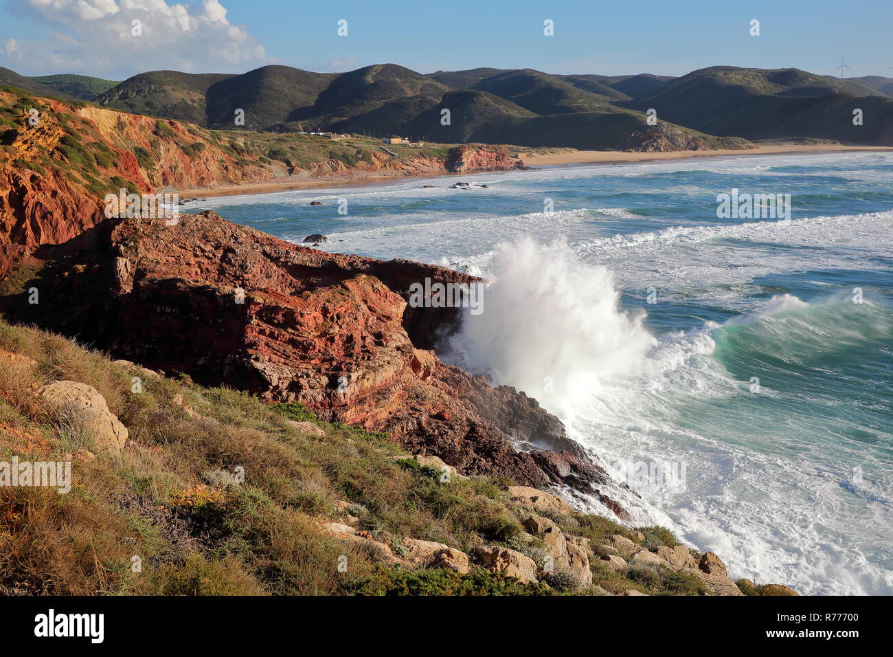 Il Rocky e colorato costa vicino a Carrapateira con Amado beach in background e forti onde, Costa Vicentina, Algarve, PORTOGALLO Foto Stock