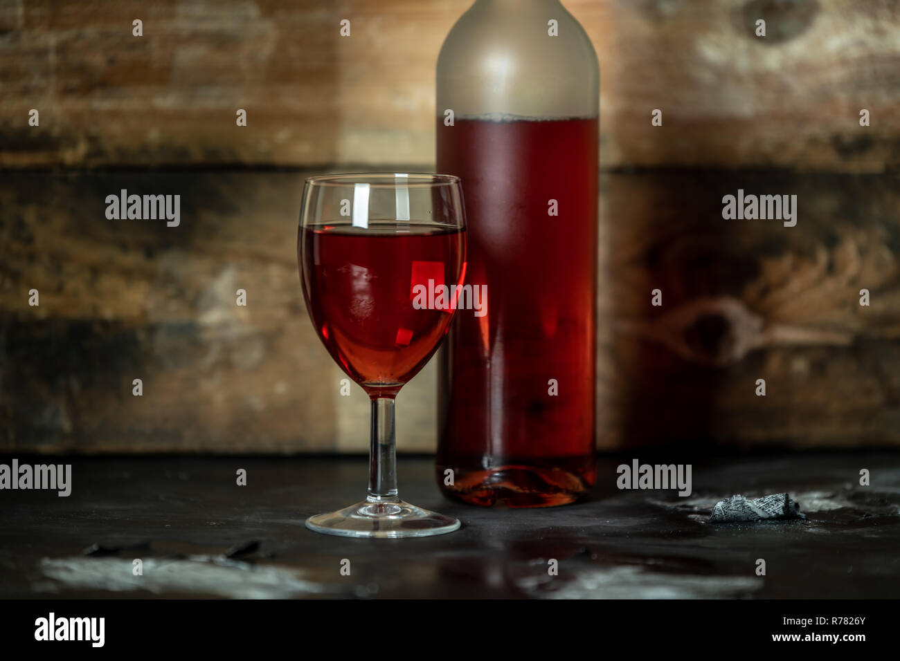 Bottiglia e bicchiere di vino rosso sul legno rustico sfondo con spazio per il testo o il proprio marchio Foto Stock