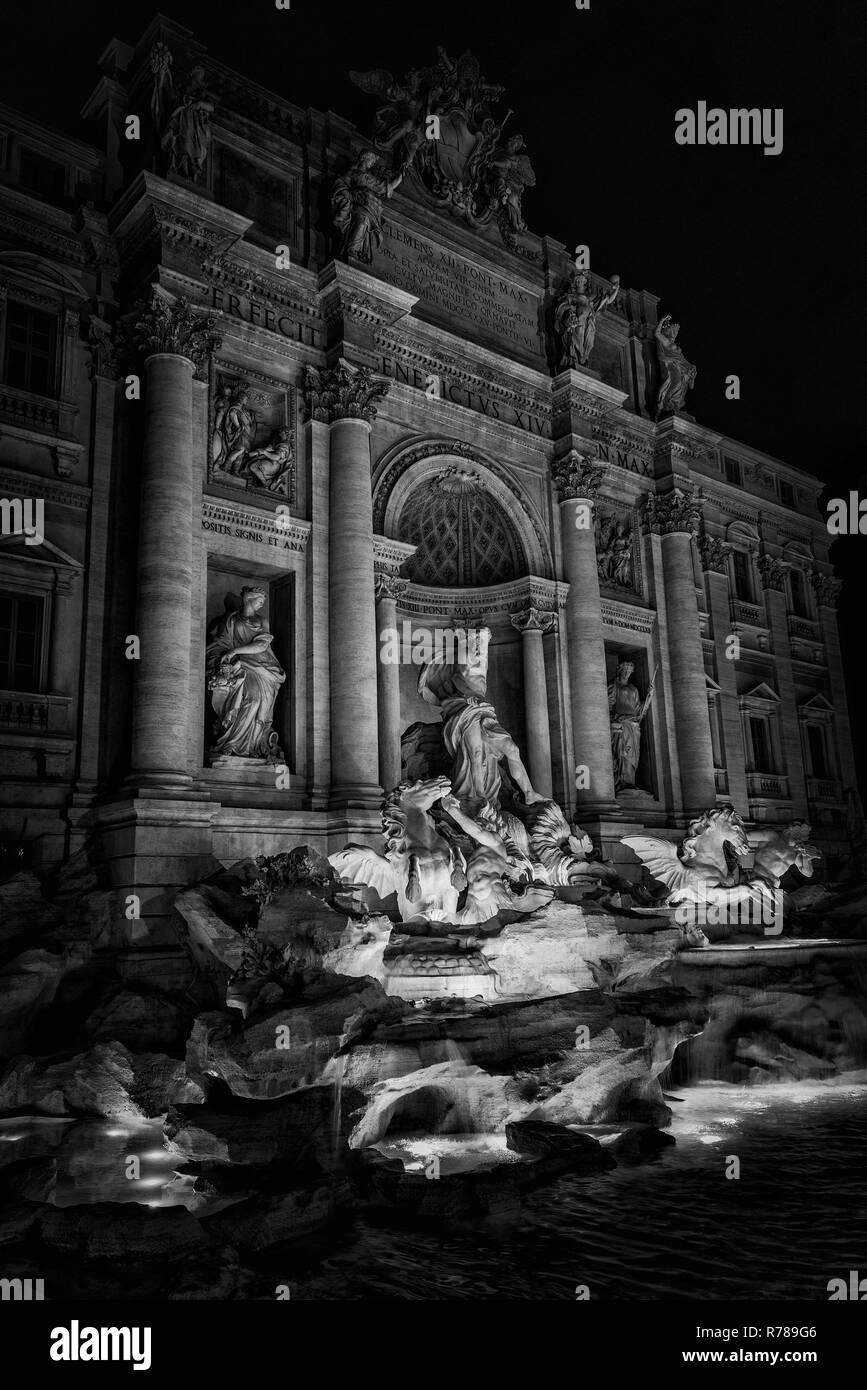 La bellissima Fontana di Trevi di notte, con l'Oceano dio e tritoni statue, completata nel XVIII secolo nel centro storico di Roma (bianco e nero) Foto Stock