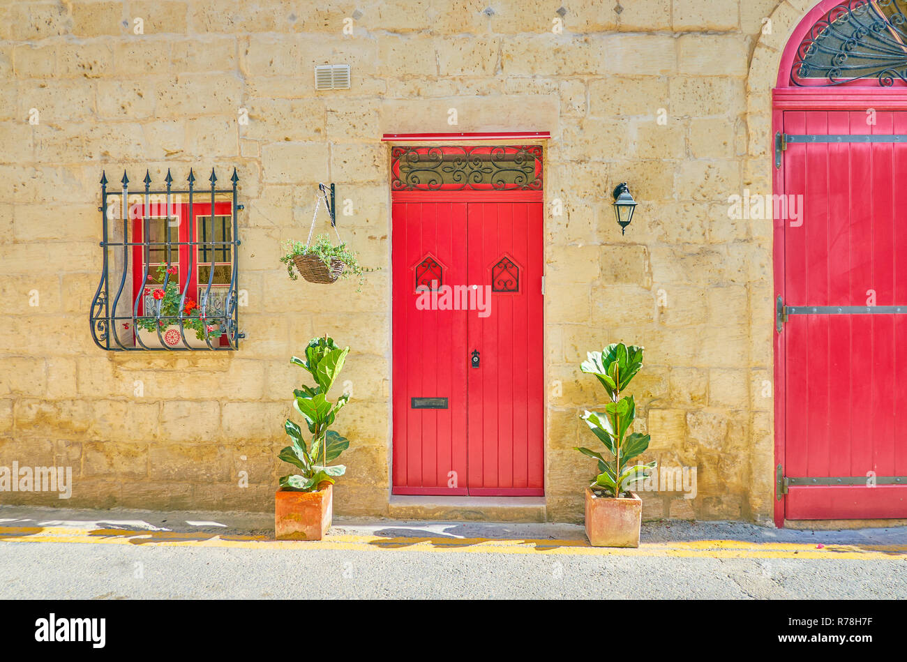 Il rosso porta di legno del vecchio palazzo residenziale nella città di Naxxar, Malta Foto Stock