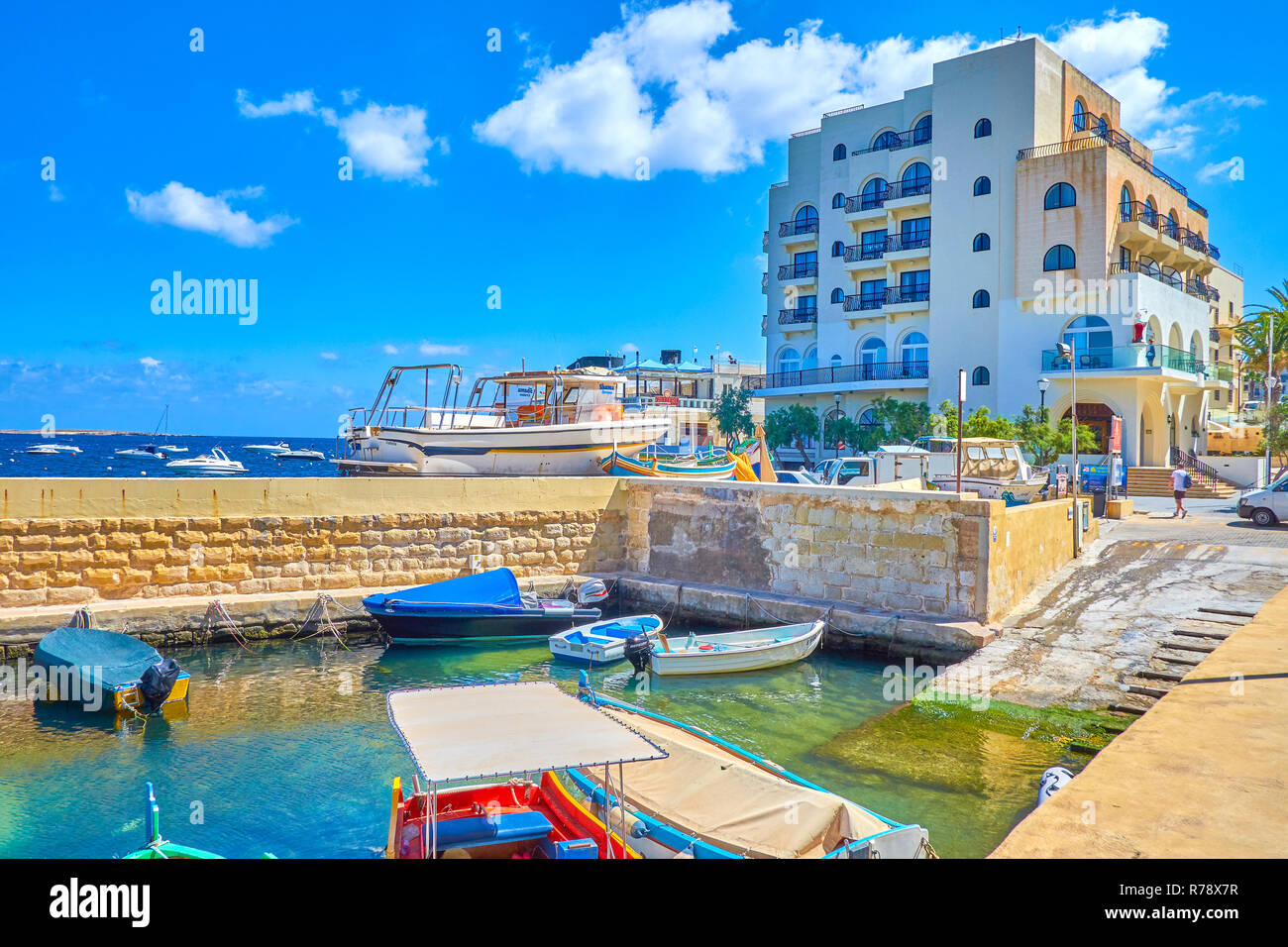 BUGIBBA, Malta - 14 giugno 2018: Il moderno hotel balneare vicini con piccolo porto, chiamato Menqa con alta scogliera di pietra, il 14 giugno a Bugibba. Foto Stock