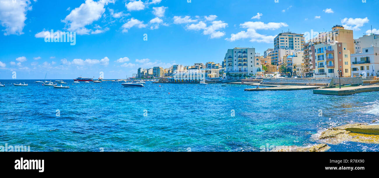 Il moderno hotel turistici e gli edifici residenziali sulla riva della st Paul Bay con il porto di pesca in primo piano, Bugibba, Malta Foto Stock
