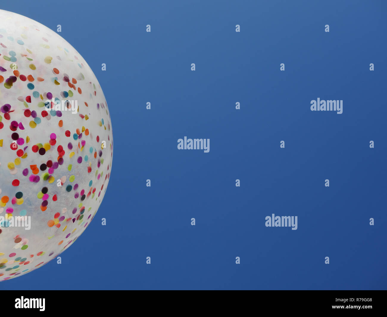 Colorato coriandoli palloncino riempito contro luminoso azzurro del cielo senza nuvole Foto Stock