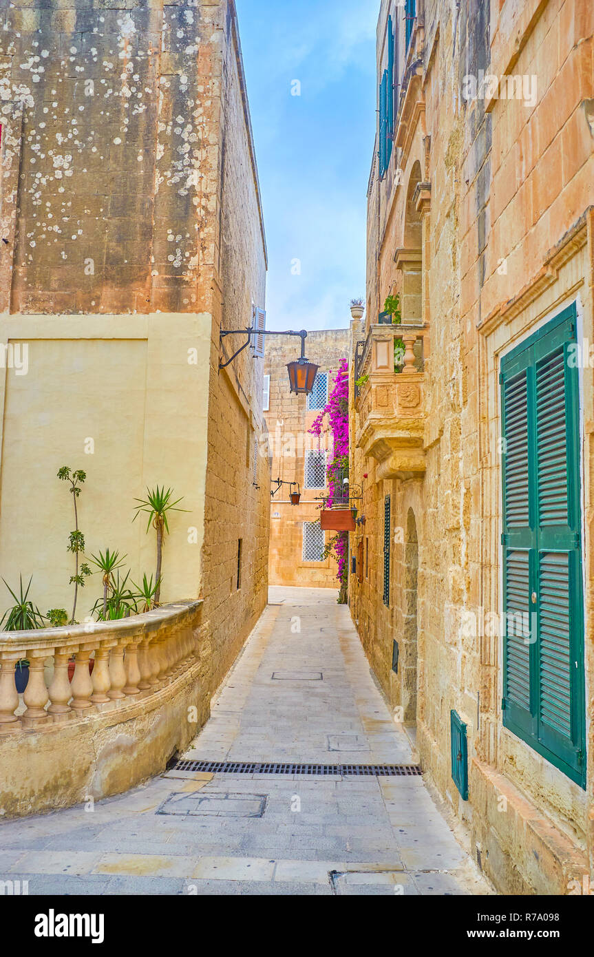 La stradina in nedieval Mdina fortezza con edifici storici con decorazioni esterne, Malta Foto Stock