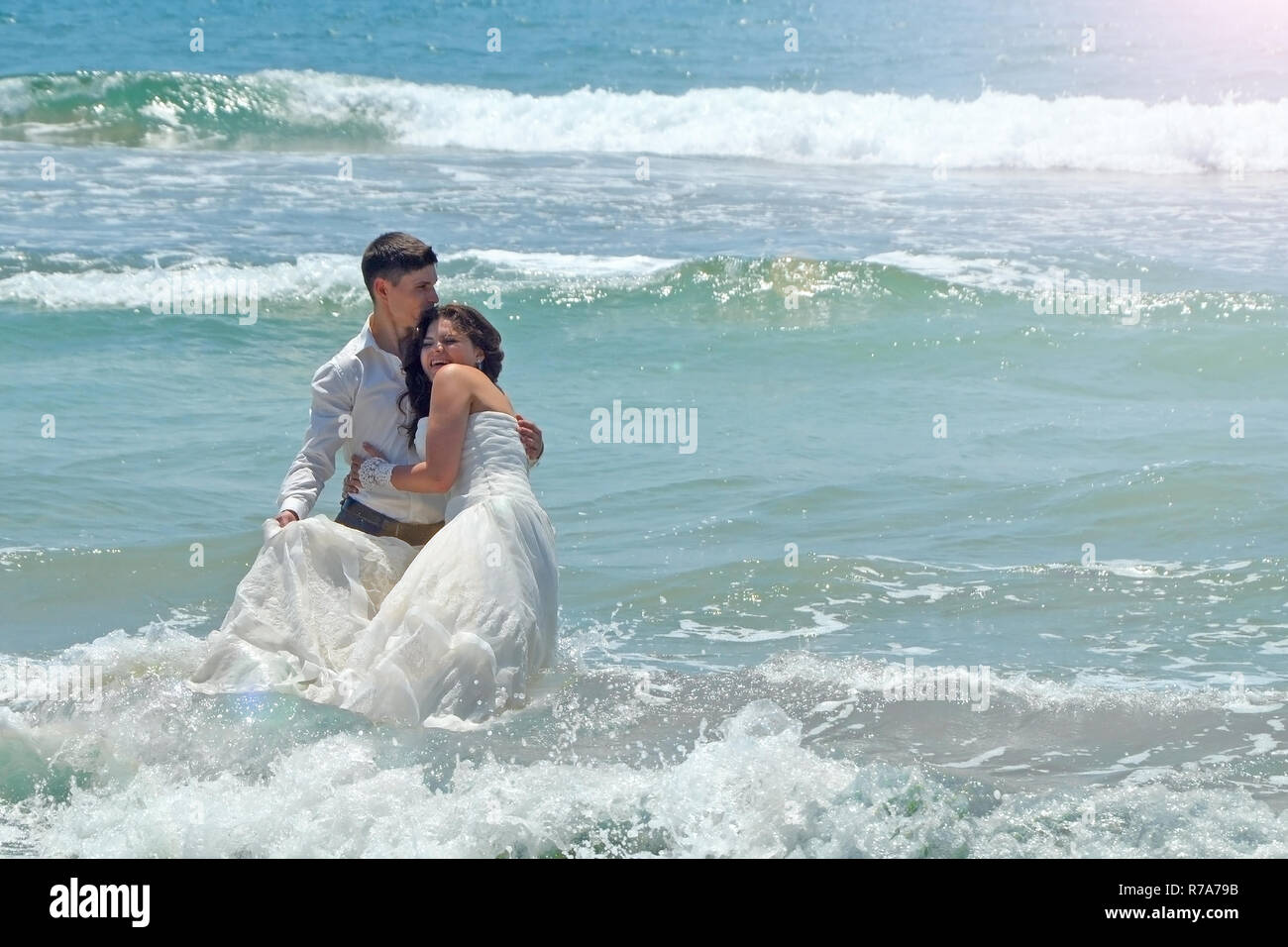 Happy sposi abbraccio e ridere nelle acque dell'Oceano Indiano. sunny giorno di nozze e luna di miele ai Tropici sull isola di Sri Lanka Foto Stock