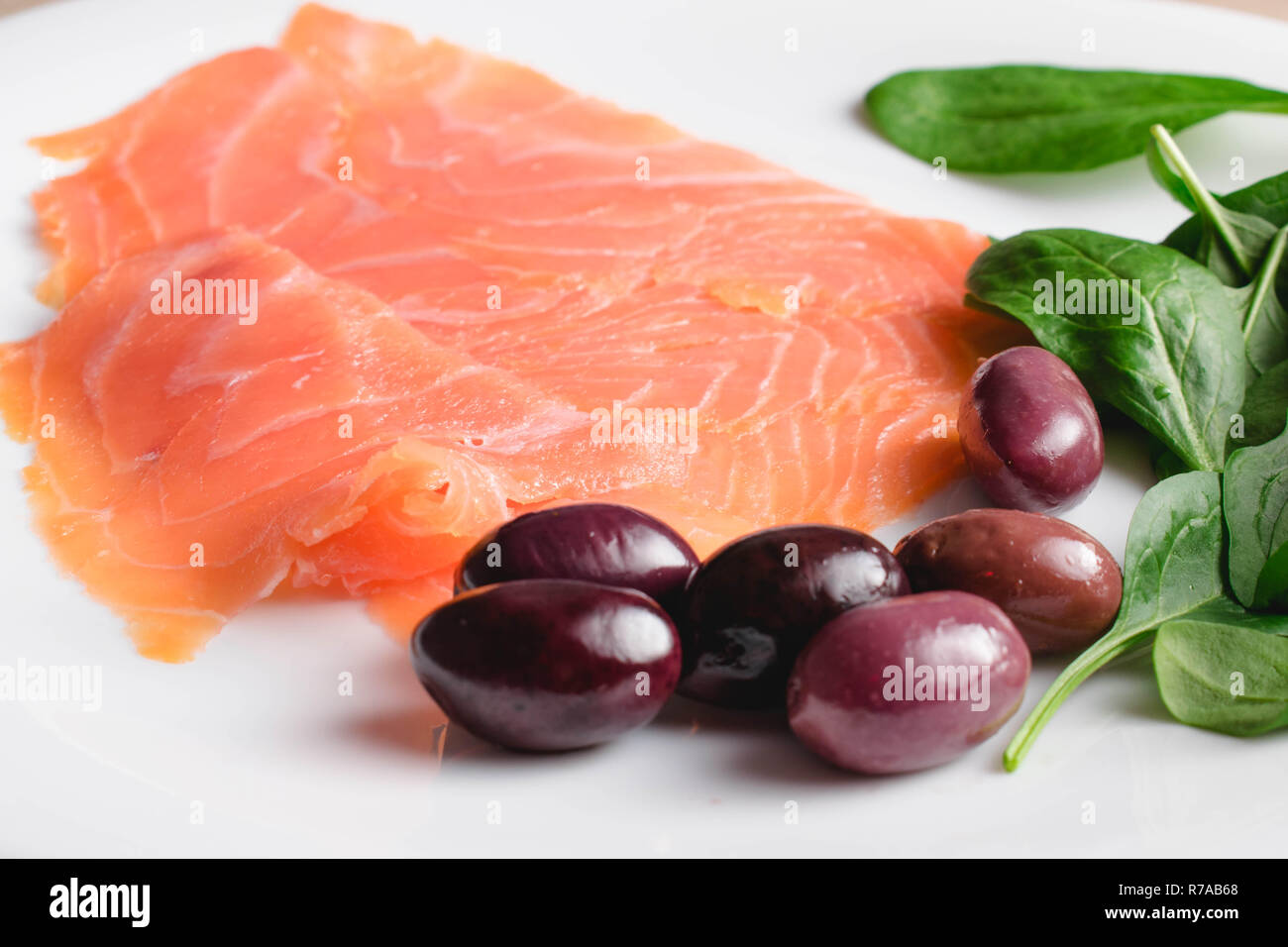 Salmone affumicato fette con olive e baby spinaci Foto Stock