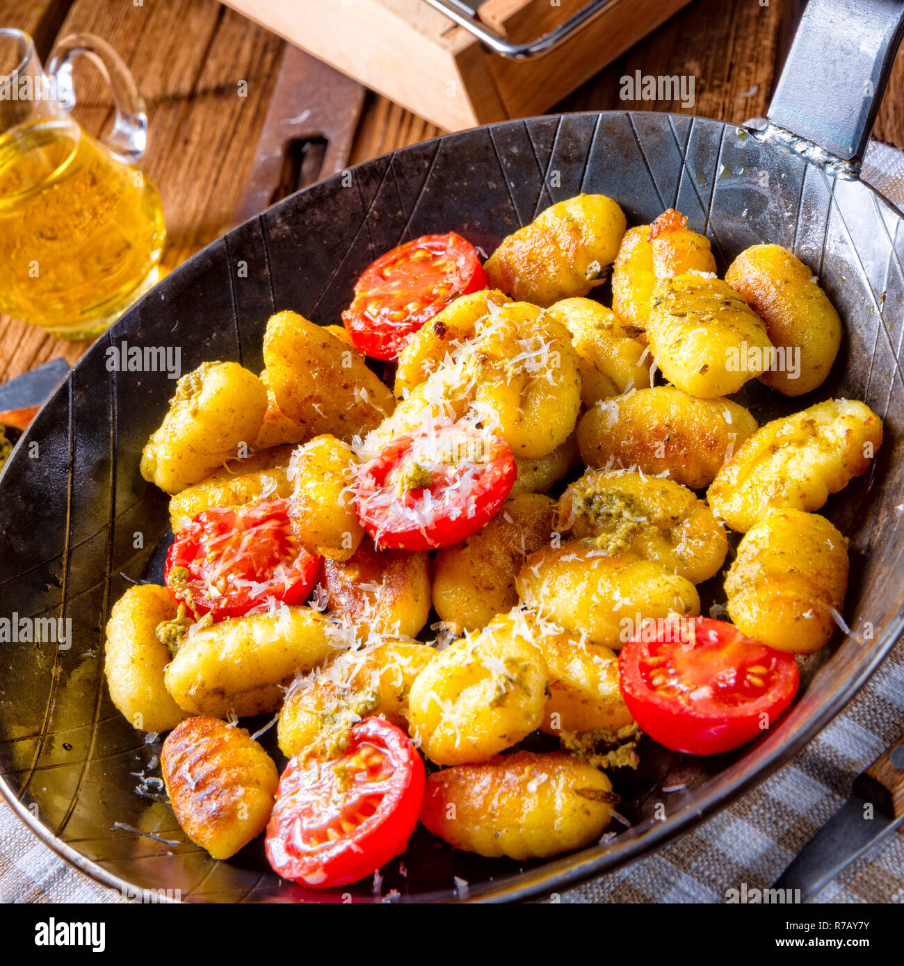 Gnocchi al forno con pesto verde,pomodorini e scaglie di parmigiano Foto Stock