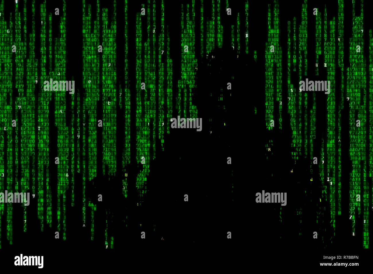 Silhouette di uomo in verde dati digitali. Il simbolo di un hacker. Foto Stock