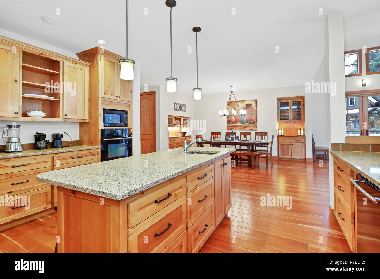 Incredibile cucina con luce armadi in legno, granito nero e apparecchi. Foto Stock