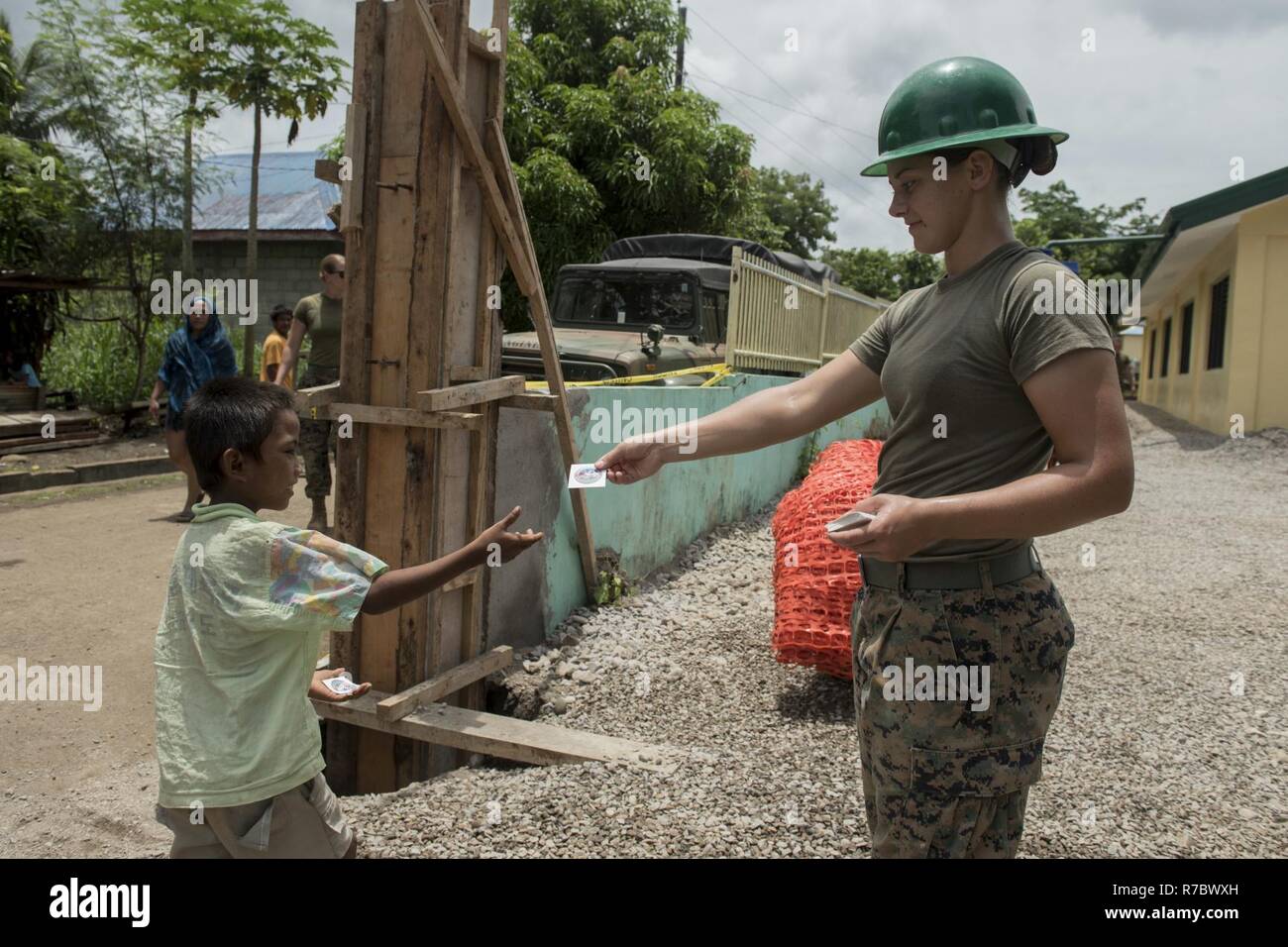 Stati Uniti Lancia Marine Cpl. Brook Klahn, destra, dà un adesivo Balikatan ad un ragazzo in un engineering assistenza civica sito del progetto a sostegno di Balikatan 2017 in Ormoc City, Leyte, 14 maggio 2017. Filippine e di servizio degli Stati Uniti i membri hanno lavorato insieme per costruire nuove aule per gli studenti di Don Carlos di scuola elementare. Balikatan è un annuale U.S.-Philippine bilaterale di esercitazione militare incentrato su una varietà di missioni, comprese la fornitura di assistenza umanitaria e di soccorso in caso di catastrofe, la lotta contro il terrorismo e altri combinati di operazioni militari. Foto Stock