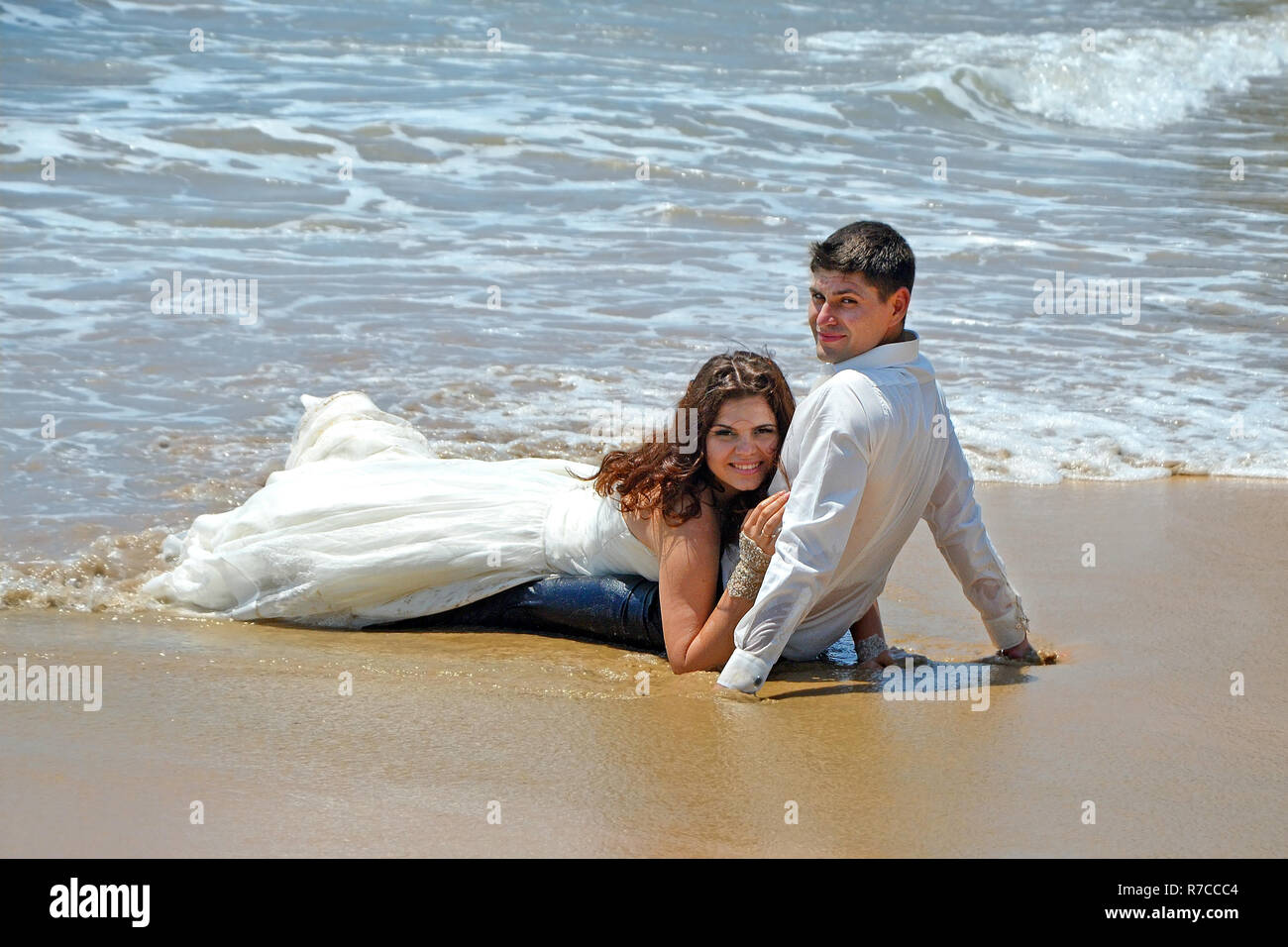Una coppia di coniugi è sdraiato sulla sabbia della spiaggia dell'Oceano Indiano. Matrimonio e luna di miele ai Tropici sull isola di Sri Lanka Foto Stock