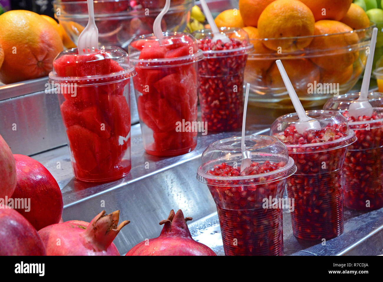 Pezzi di frutta fresca e bacche di un melograno in bicchieri di plastica sul contatore. Fresche, snack sani sono venduti in un mercato di Gerusalemme, Israele. Foto Stock