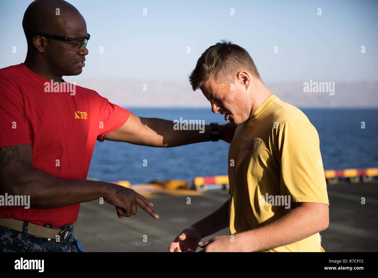 5TH FLOTTA AREA DI OPERAZIONI (11 maggio 2017) Capo specialista culinari Stephan Smith incarica il marinaio Brynley poteri per aprire gli occhi dopo che viene spruzzato con oleoresina capsaicina (OC) Spray durante la sicurezza della forza di reazione della formazione a bordo dell'assalto anfibio nave USS Bataan (LHD 5). La nave e il suo gruppo pronto sono distribuiti negli Stati Uniti Quinta Flotta area di operazioni a sostegno della sicurezza marittima operazioni destinate a rassicurare gli alleati e partner e preservare la libertà di navigazione e il libero flusso di commercio nella regione. Foto Stock