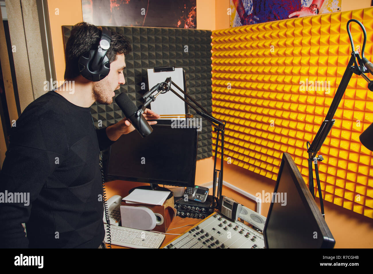 Microfono in studio radio e presentatore sullo sfondo. Foto Stock