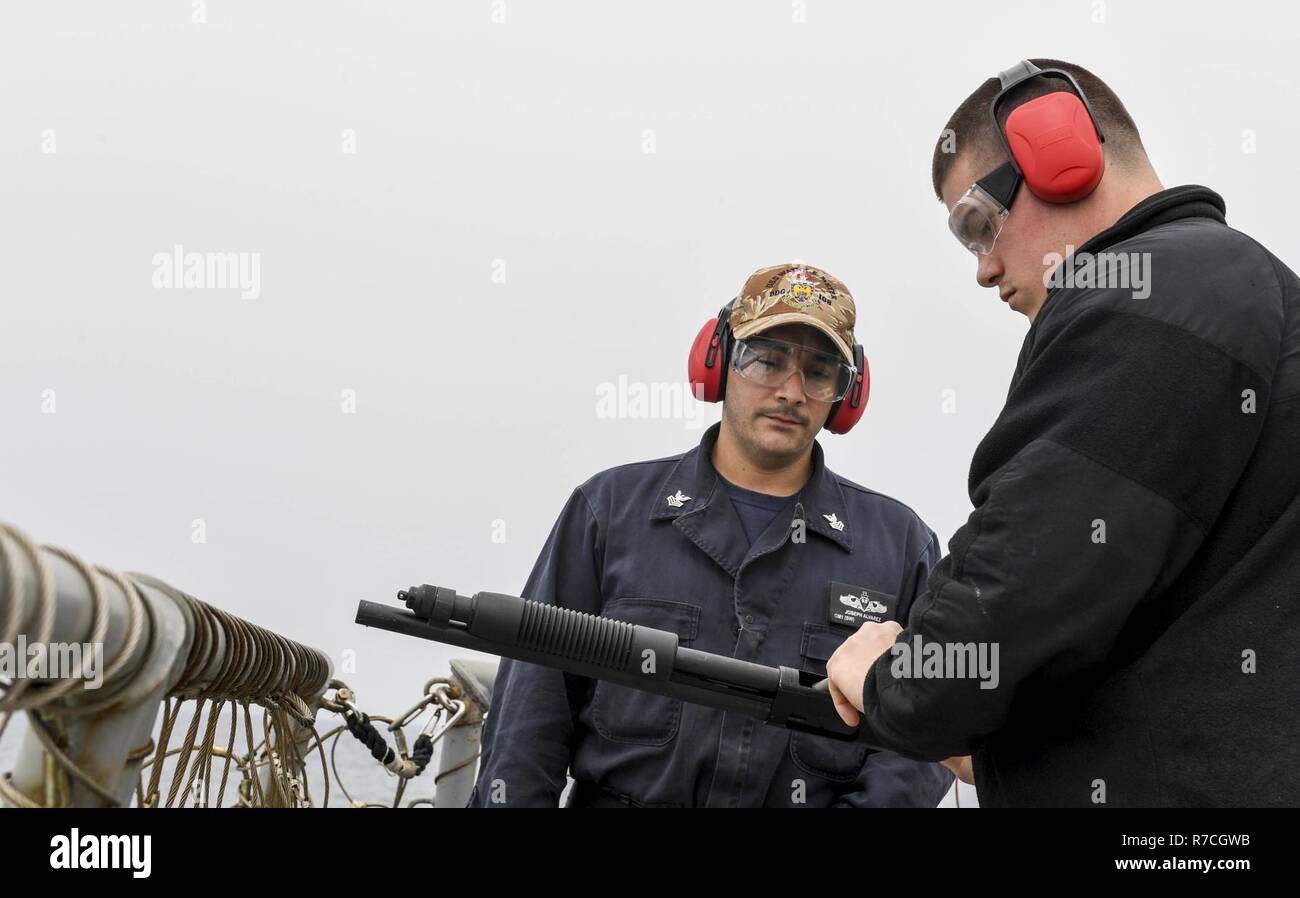 Pacifico occidentale (12 maggio 2017) da bombardieri mate 1. Classe Giuseppe Alvarez (sinistra), da San Diego, agisce come un campo Supervisore come tecnico elettronico 2a classe Miguel Hernandez, dal mastice, New York, carichi di munizioni in un Mossberg 500 fucile durante una familiarizzazione live-fire sparare a bordo Arleigh Burke-class guidato-missile destroyer USS Wayne E. Meyer (DDG 108) STATI UNITI Marina ha pattugliato il Pacifico Indo-Asia di routine per più di 70 anni regionale di promozione della pace e della sicurezza. Foto Stock