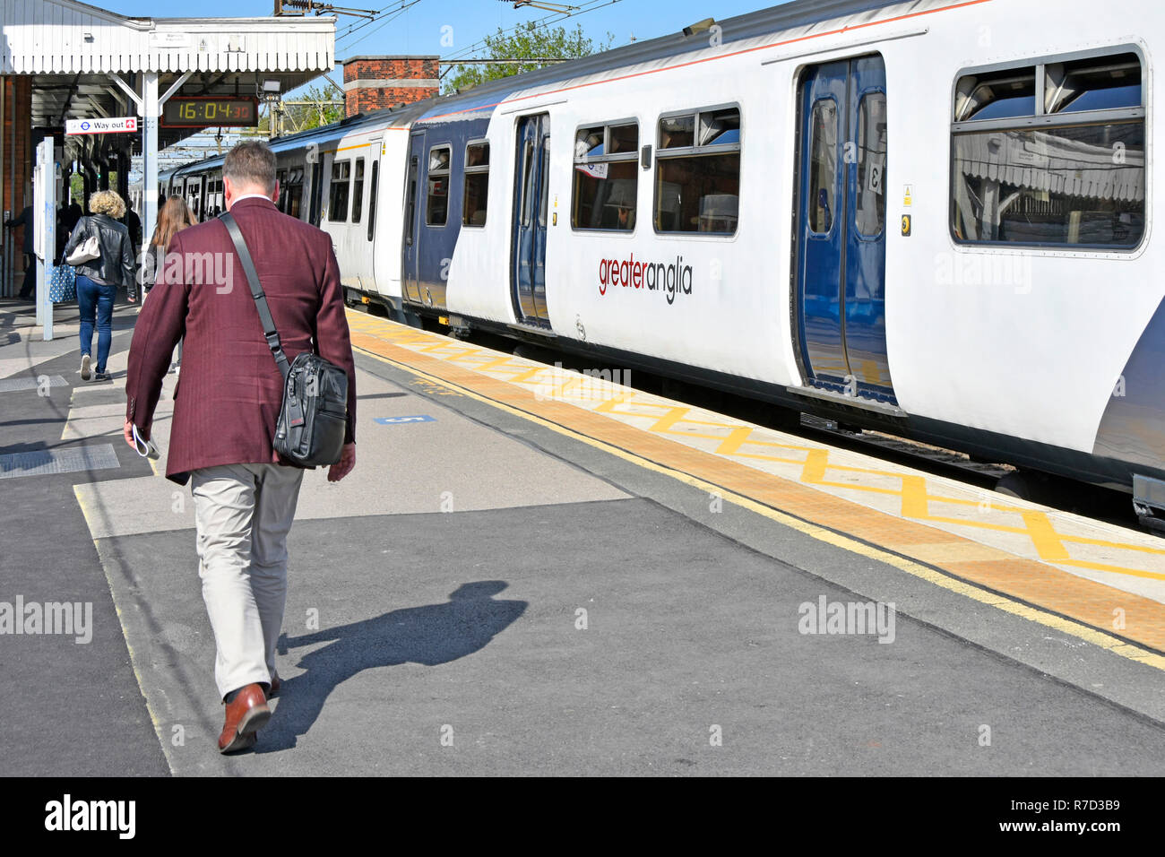 Passeggeri a piedi lungo la piattaforma dopo che viaggiano su una maggiore Anglia servizio pendolare da Londra treno Partenze Shenfield stazione ferroviaria Essex REGNO UNITO Foto Stock
