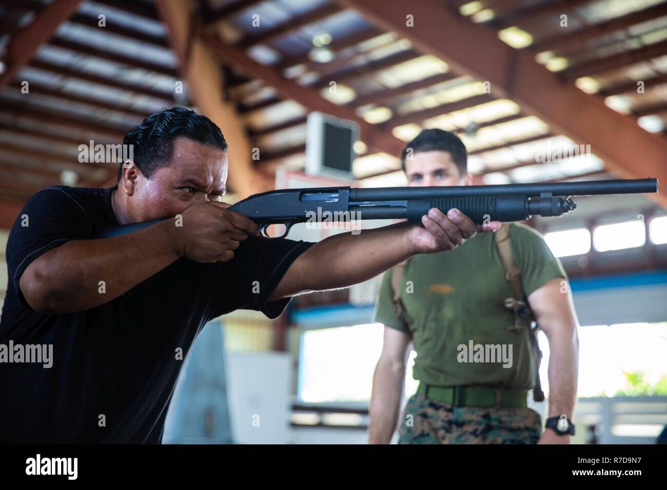 KOROR, Repubblica di Palau - STATI UNITI Marine Corps Cpl. Jarod Breeser, destra, leader di un team con le forze di polizia di distacco, Task Force Koa Moana, sovrintende Palauan funzionario di polizia Sesario Gibbons, un funzionario di correzioni con Palau forza di polizia, prassi corretta Mossberg 500 azione pompa fucile tecniche di ripresa durante la tattica difensiva della classe di formazione a Palau Palestra nazionale, nov. 27. TFKM Marines e marinai distribuito per effettuare impegni multilaterali volti a rafforzare e migliorare le relazioni tra gli Stati Uniti e i paesi partner nell'Indo-Pacifico e Sud Pacifico. Foto Stock