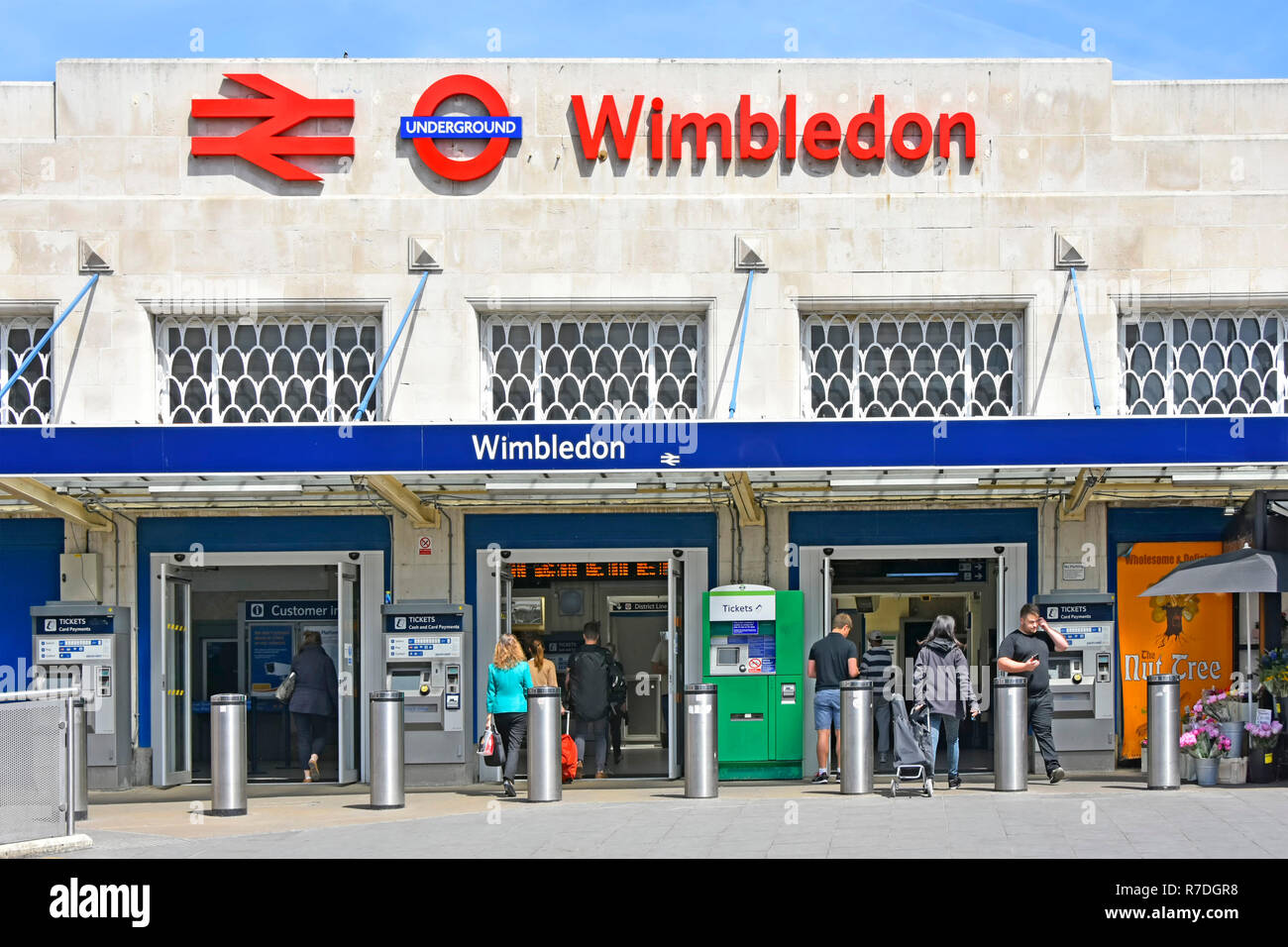 Sign & logo sopra i mezzi di trasporto pubblico di persone entrata a Wimbledon National Rail & London Underground stazione ferroviaria e stazione tramlink Londra Inghilterra REGNO UNITO Foto Stock
