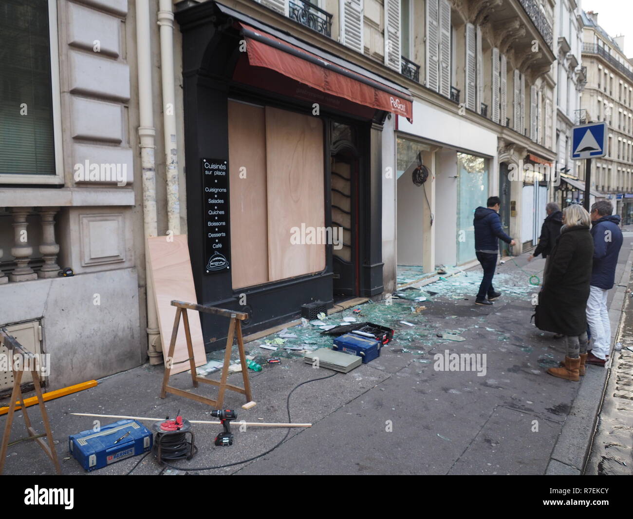 Parigi, Francia. 9 Dic 2018. Passanti di assistere alla distruzione di vetrine su Avenue Marceau nel 8° distretto di Parigi, un giorno dopo il giallo West dimostrazioni. Il movimento di protesta del 'giallo gilet" era formata a metà novembre in vista del previsto aumento delle imposte sui carburanti. Nel frattempo, le richieste si spingono molto più in là. (A dpa " di più di 1700 arresti a 'giacche gialle' dimostrazioni in Francia ") Foto: Christian Böhmer/dpa Credito: dpa picture alliance/Alamy Live News Foto Stock