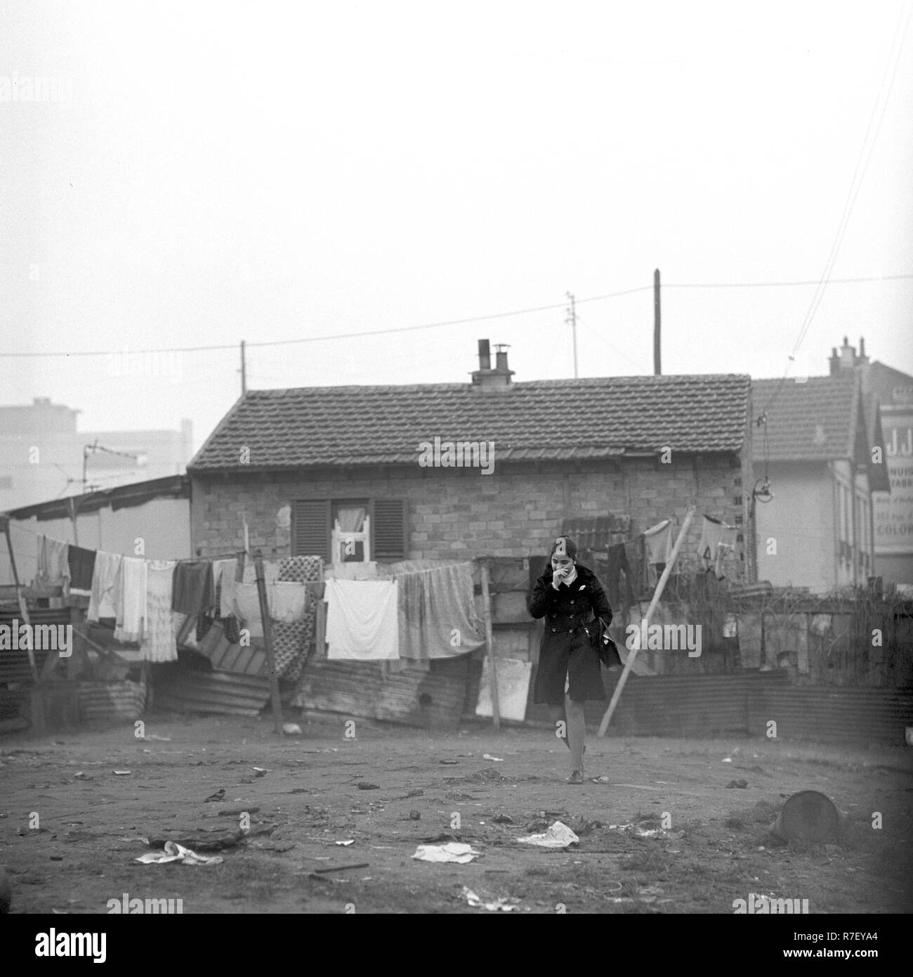Una donna è raffigurato nella parte anteriore di una casa in una delle baraccopoli vicino a Parigi, in Francia nel novembre 1970. Il quarto, che principalmente è stato abitato da immigrati, è stata abbandonata. Foto: Wilfried Glienke | Utilizzo di tutto il mondo Foto Stock