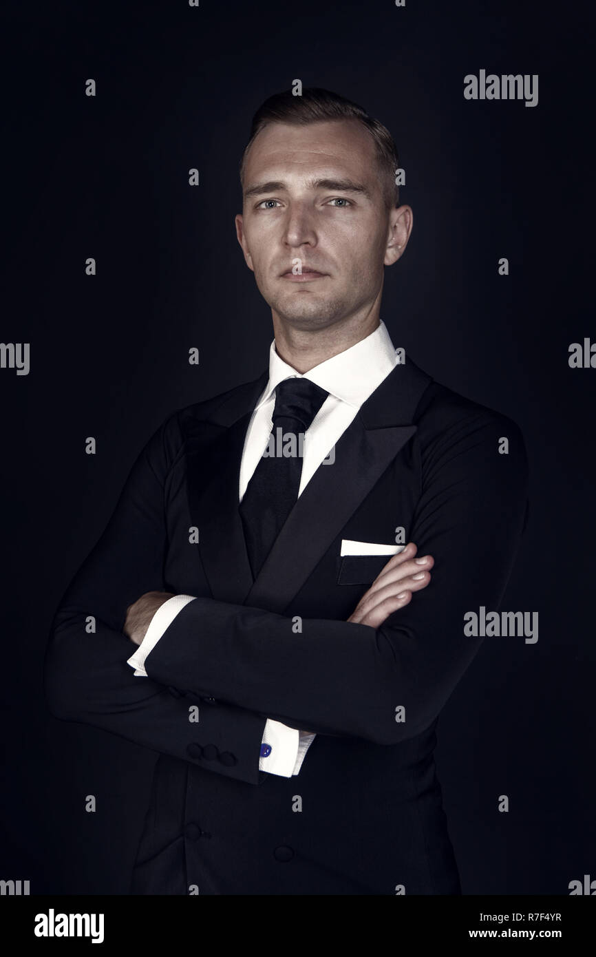 L'uomo. business man in un nero Tuxedo tuta e camicia bianca e cravatta nera  su sfondo nero. L imprenditore nel buio. l uomo stile formale. Studio shot  Foto stock - Alamy