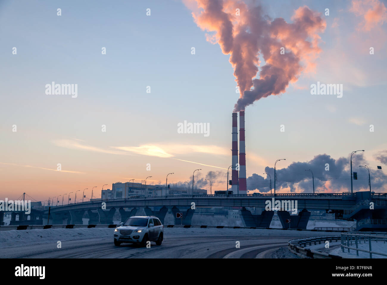 Paesaggio urbano corse in auto sullo sfondo del ponte, fumo di tubazioni di fabbrica inquina atmosfera. Concetto di petrolio, carbone e gas naturale trasformazione, inquinamento di environmen Foto Stock