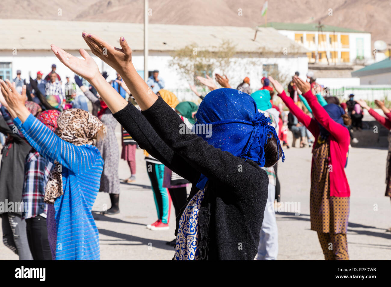 Murghab, Tagikistan, 23 agosto 2018: Kirghizistan le ragazze e le giovani donne sono la pratica di una danza sul campo da gioco di una scuola a Murghab. Contro il forte Foto Stock