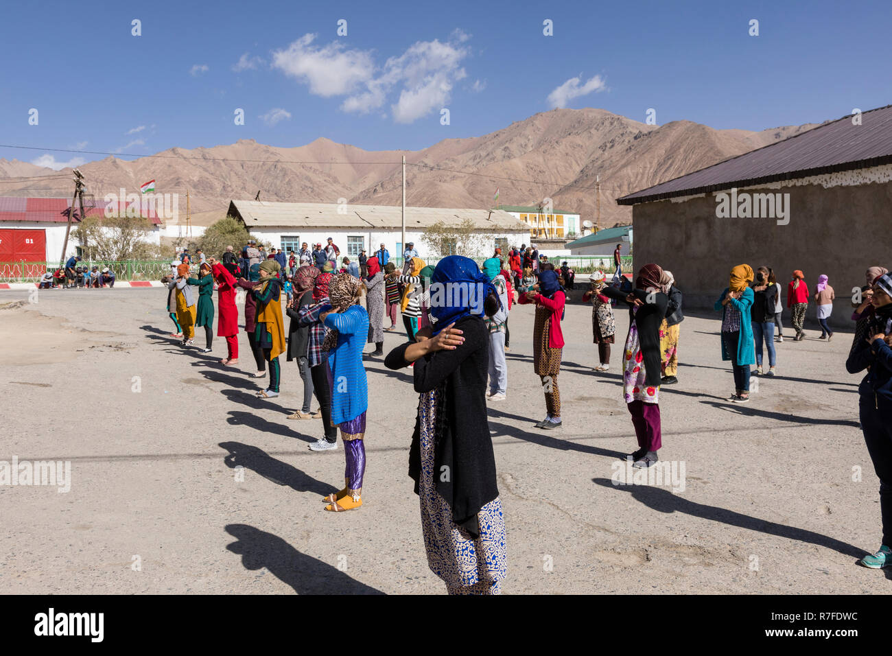 Murghab, Tagikistan, 23 agosto 2018: Kirghizistan le ragazze e le giovani donne sono la pratica di una danza sul campo da gioco di una scuola a Murghab. Contro il forte Foto Stock