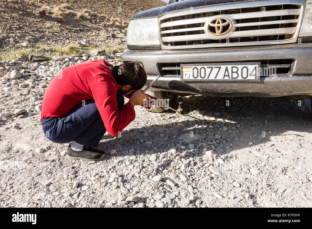 Langar, Tagikistan, 23 agosto 2018: la riparazione di un pneumatico sgonfio in Pamir autostrada vicino Langar nella zona di confine tra il Tagikistan e Afghanistan Foto Stock