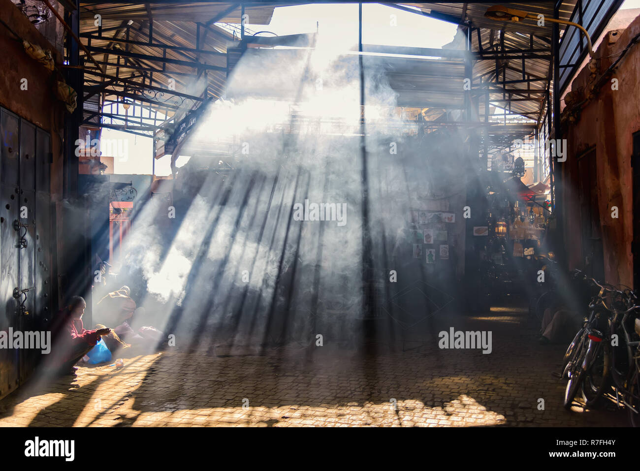 Marrakech, Marocco - 30 dicembre 2017: la luce del sole di entrare nel buio Souk Haddadine. Un souq o souk è un marketplace o quartiere commerciale Foto Stock