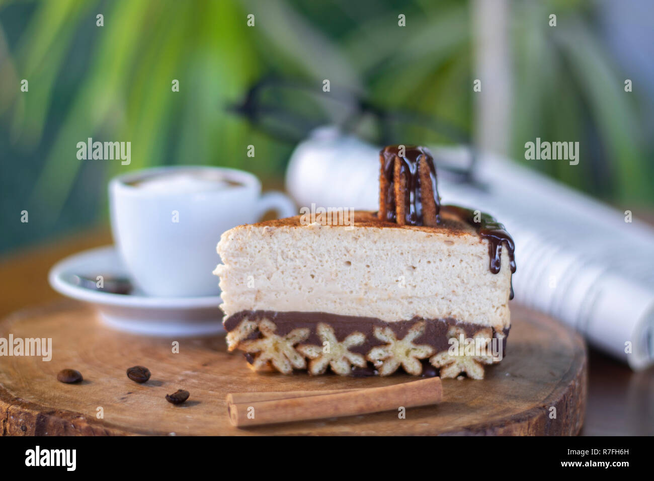 Churros cheesecake e caffè macchiato con libro e bicchieri sfondo sulla tavola di legno Foto Stock