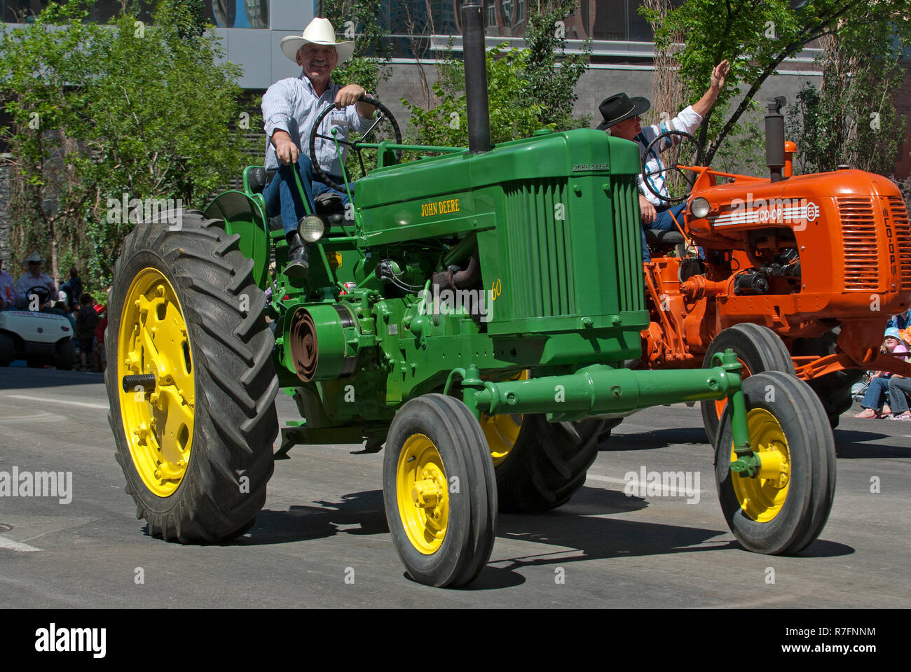 Gli uomini la guida del trattore durante la Calgary Stampede Parade, Calgary, Alberta, Canada Foto Stock