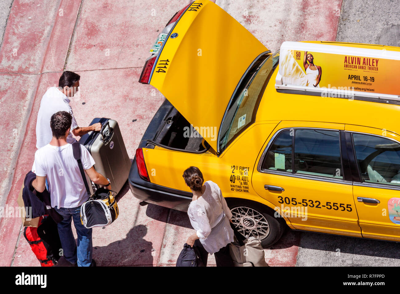 Miami Beach Florida, Ocean Drive, taxi, taxi, taxi, taxi, taxi, colore giallo, adulti uomo uomo uomini uomini uomini, donna donna donna donna donna donna donna donna donna donna donna donna donna, coppia, conducente, bagagliaio, bagagli, valigie Foto Stock