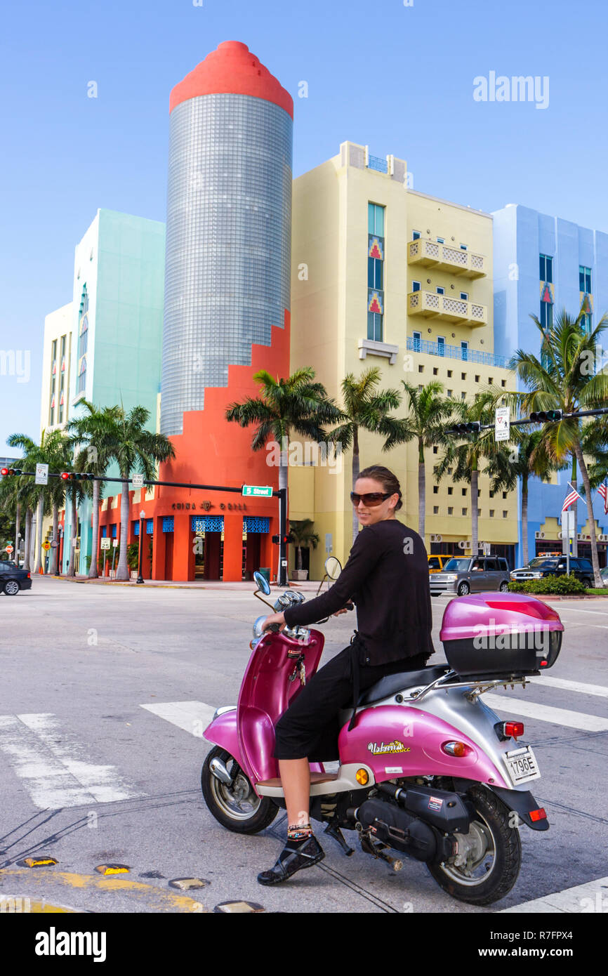 Miami Beach Florida,Washington Avenue,5th Fifth Street,incrocio,angolo,donna donne,scooter,Urban Classic,luce rossa,fermata,sorridente,felice,lo Foto Stock