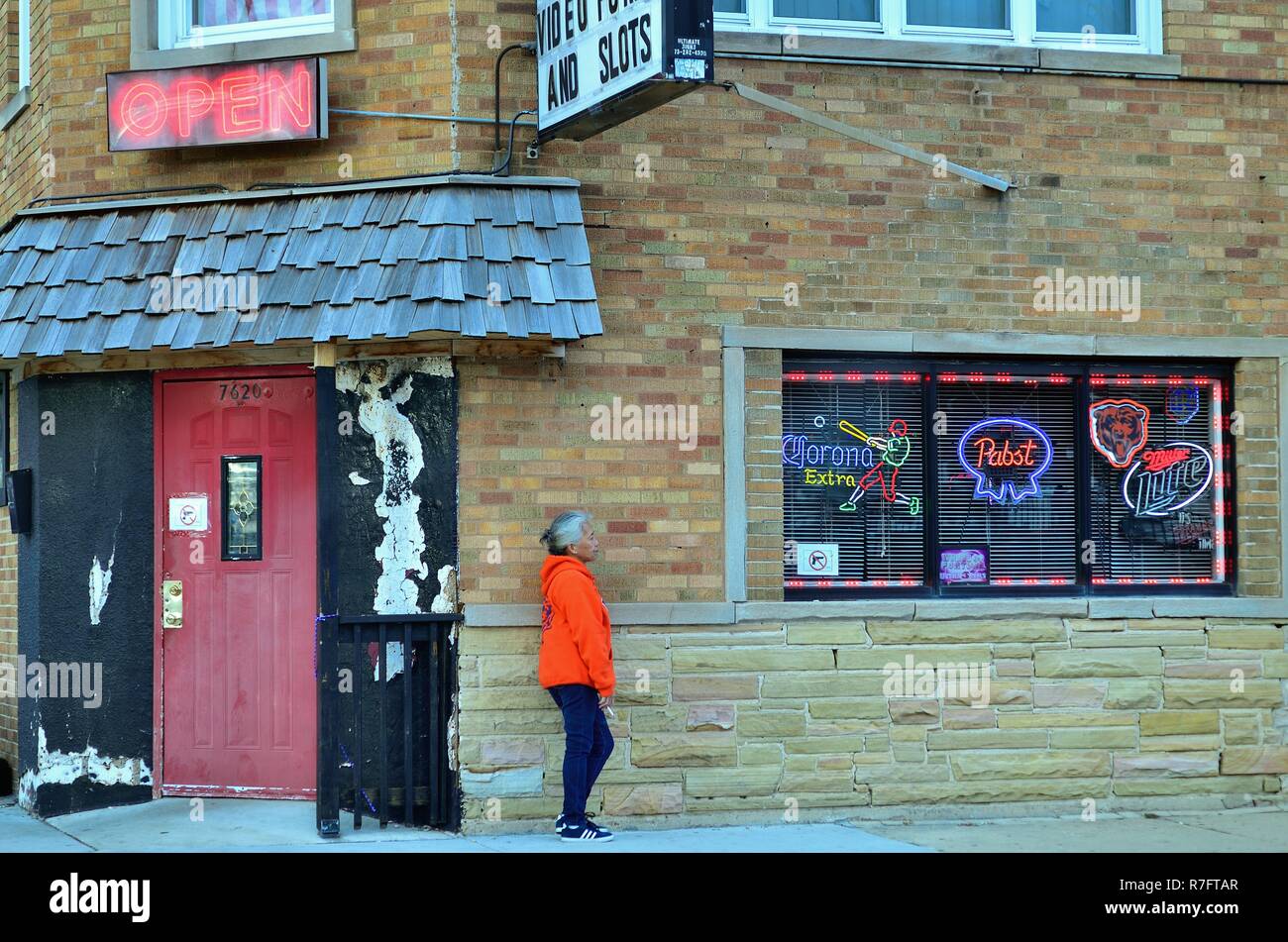 Chicago, Illinois, Stati Uniti d'America. Con le leggi che vietano di fumare all'interno di luoghi pubblici, una donna, come molti fumatori capi fuori in risposta al suo addiciton. Foto Stock