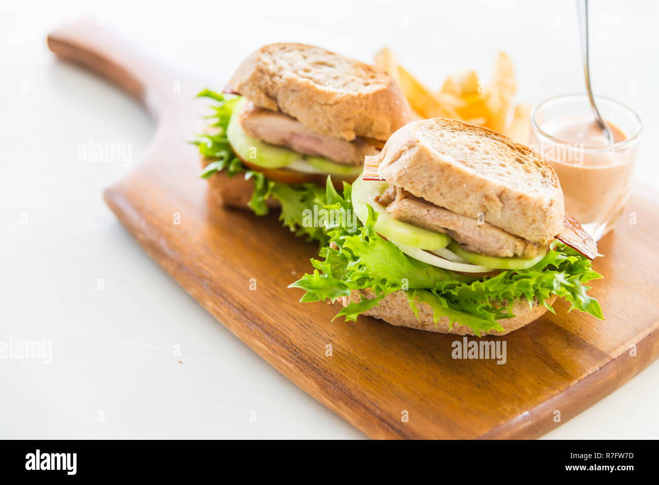 Sandwich di pollo e patatine fritte sul vassoio di legno Foto Stock