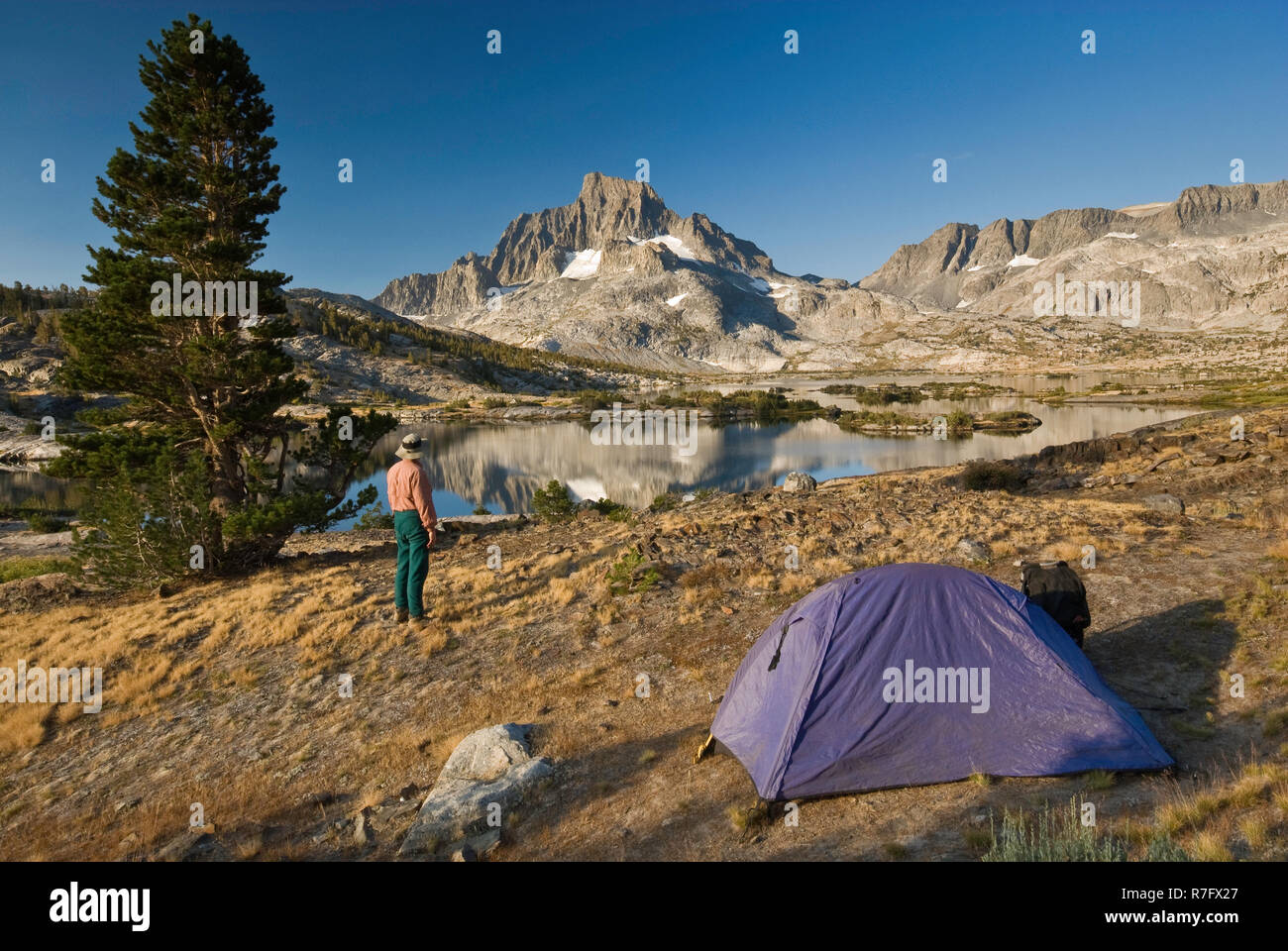 Escursionista presso camping a mille isole lago sotto il banner di picco e di gamma Ritter, John Muir Trail, Sierra Nevada, Ansel Adams Wilderness, CALIFORNIA, STATI UNITI D'AMERICA Foto Stock