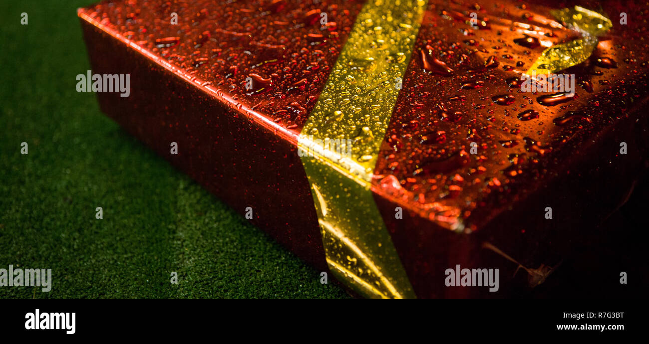 Confezione regalo rossa - un regalo di Natale. Avvolte si presenta con colore rosso brillante background. Foto Stock
