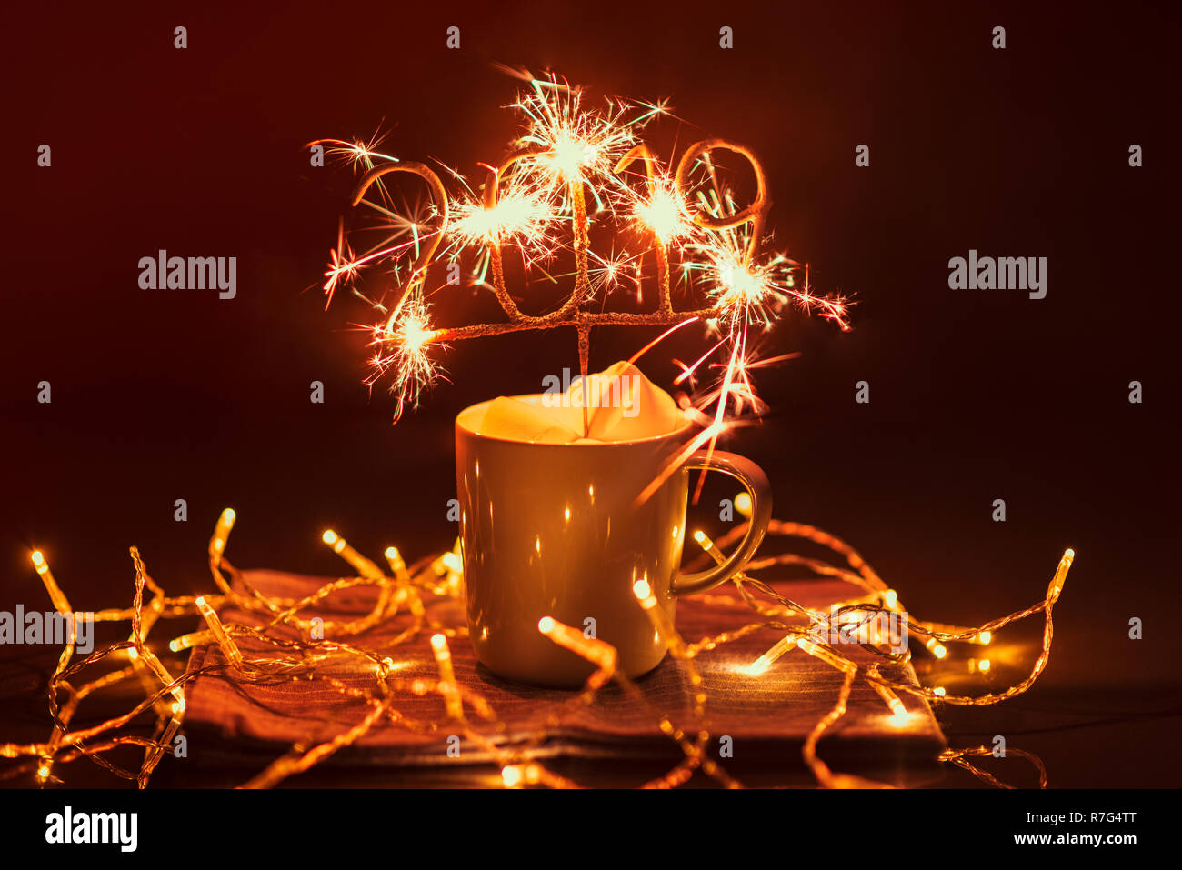 2019 forma infiammando Sparkler in tazza con Marshmallows sul tavolo esterno di notte Foto Stock