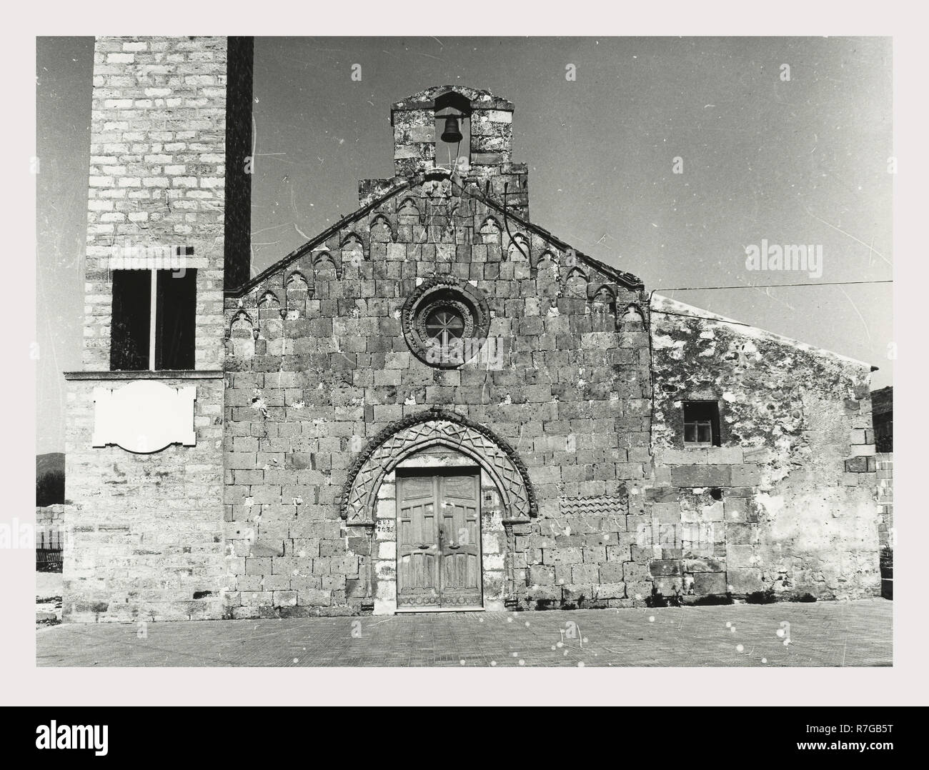 Sassari Sardegna Coghinas S. Maria, questa è la mia Italia, il paese italiano di visual storia medievale di architettura romanica con moderno campanile. La facciata presenta un portale in forma di un arco moresco, un piccolo rosone e la piccola torre campanaria e decorativi archi di trifoglio lungo il cornicione pietre scolpite con motivi geometrici appaiono intorno arch, finestra e sulla facciata Foto Stock