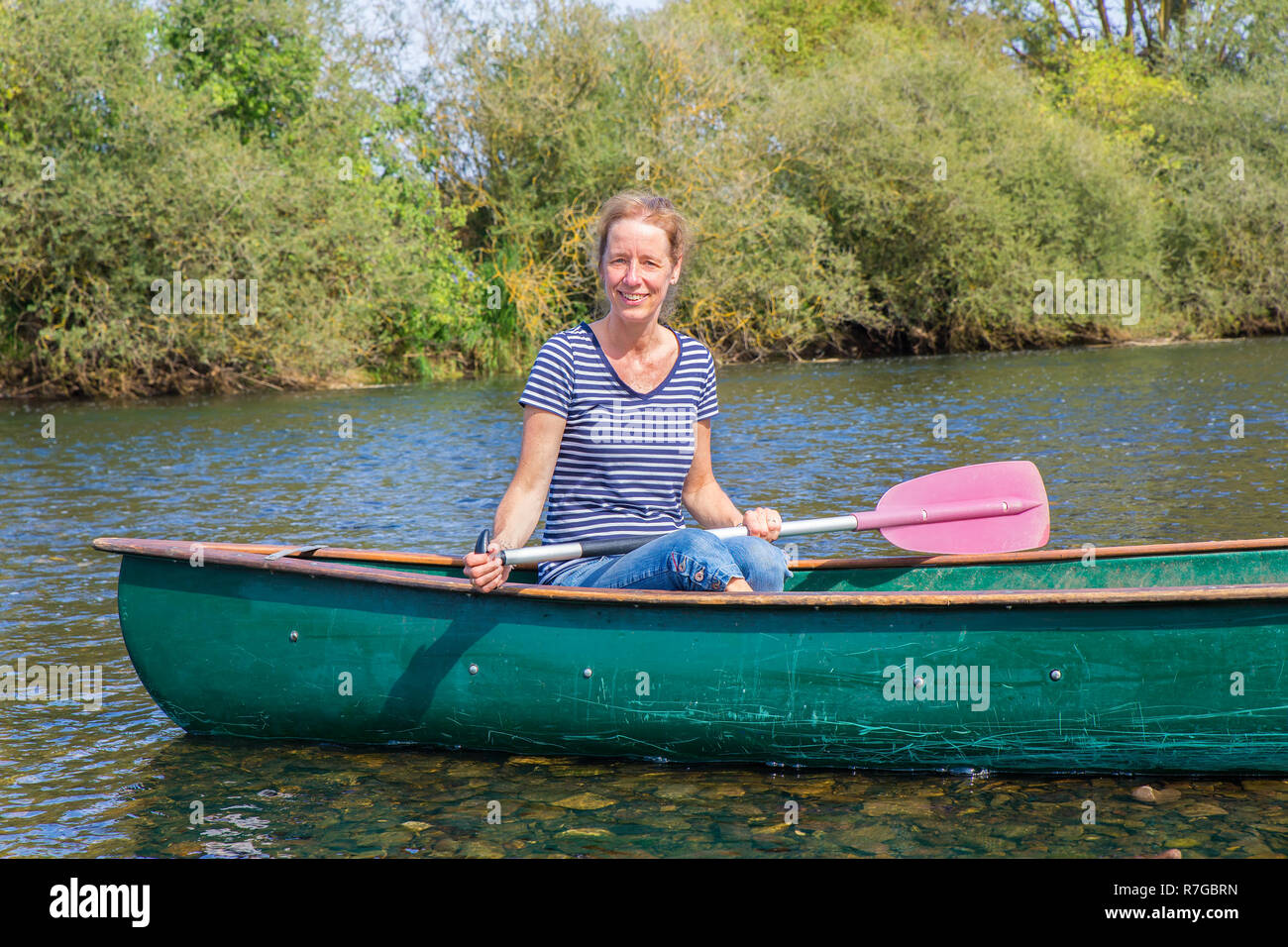 La donna caucasica posa con pagaia in canoa sulle acque del fiume tedesco Foto Stock