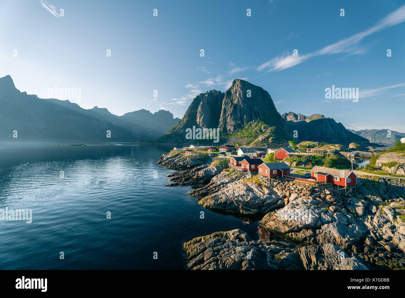 Red rorbu capanne da un oceano di calma a sunny serata estiva in isole Lofoten Reine, Norvegia Foto Stock