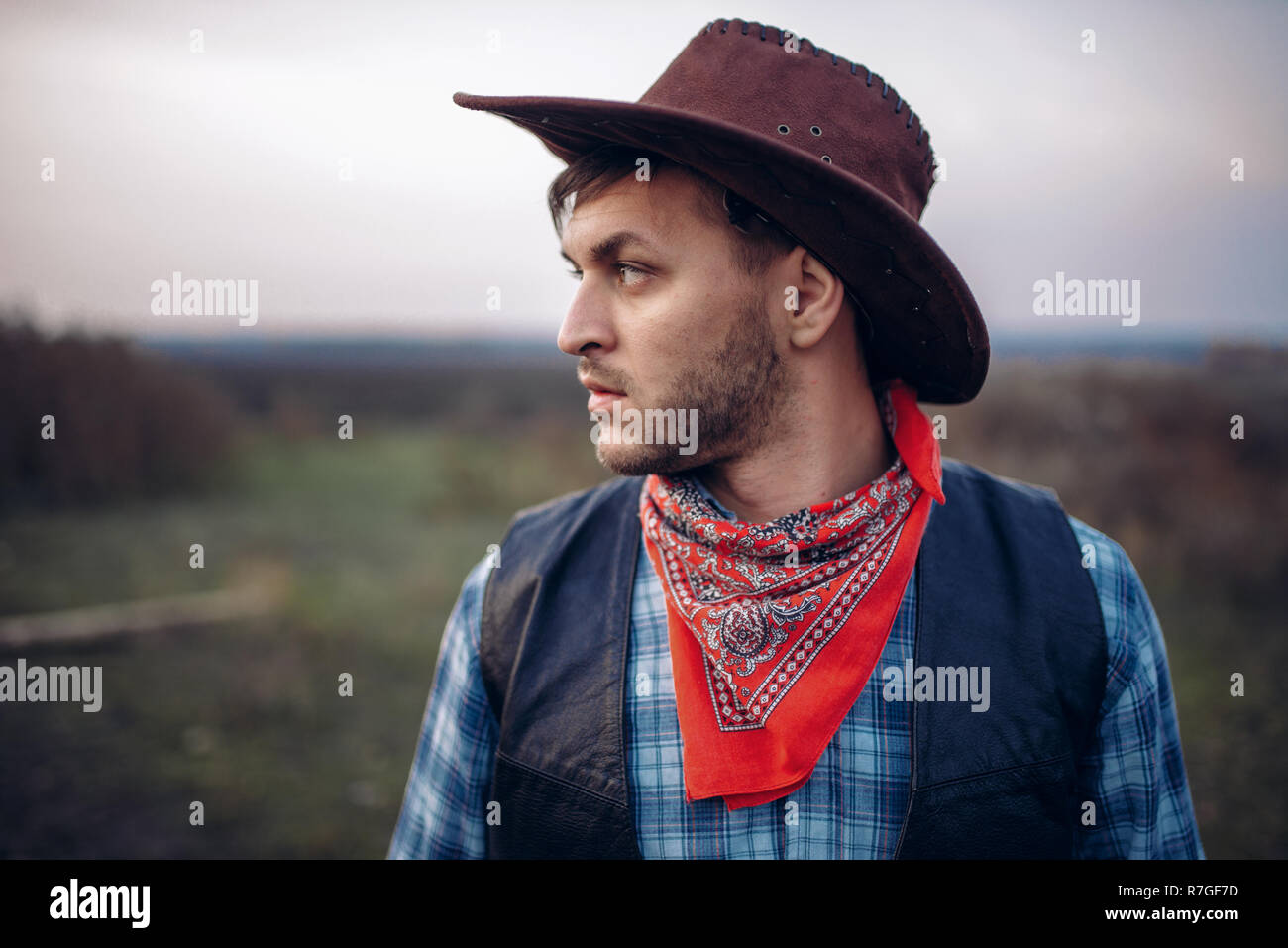 Ritratto di brutale cowboy in giacca di pelle e cappello, occidentale. Vintage persona maschile, retrò moda americana nel selvaggio west style Foto Stock