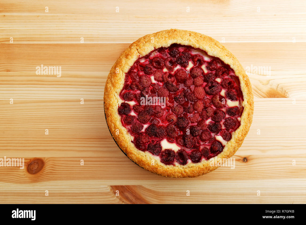 In casa la cheesecake con lampone su un tavolo di legno. Vista dall'alto. Copyspace. Foto Stock