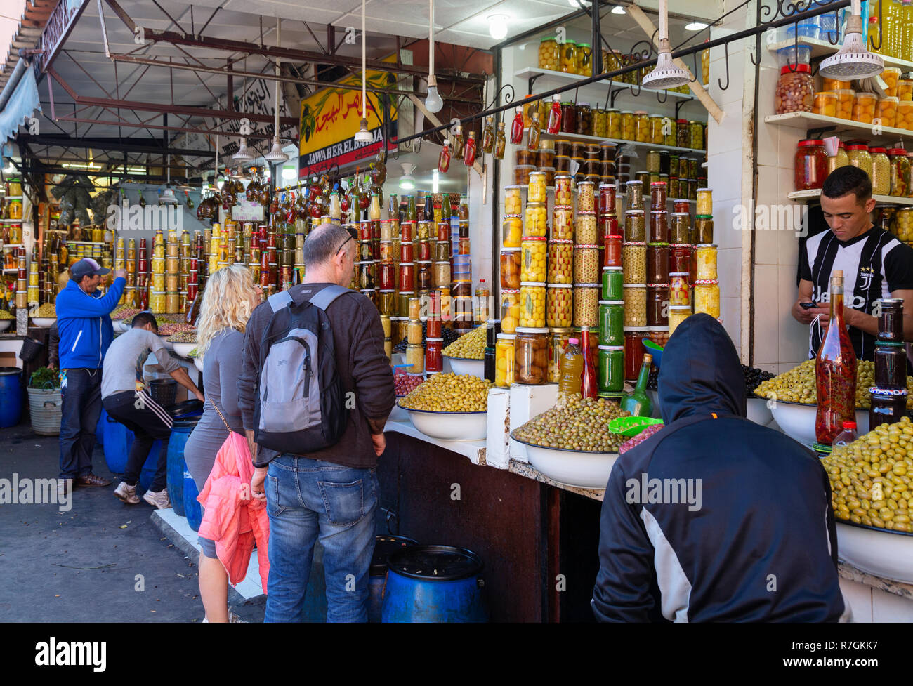 Tourist shopping e di acquisto di beni nel mercato alimentare o souk, Marrakech Medina, Marrakech, Marocco Foto Stock