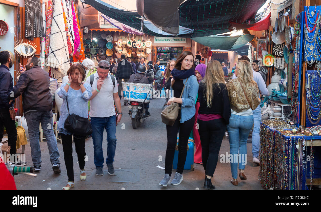 I turisti shopping e di acquisto di beni nel souk, Marrakech Medina, Marrakech, Marocco Foto Stock
