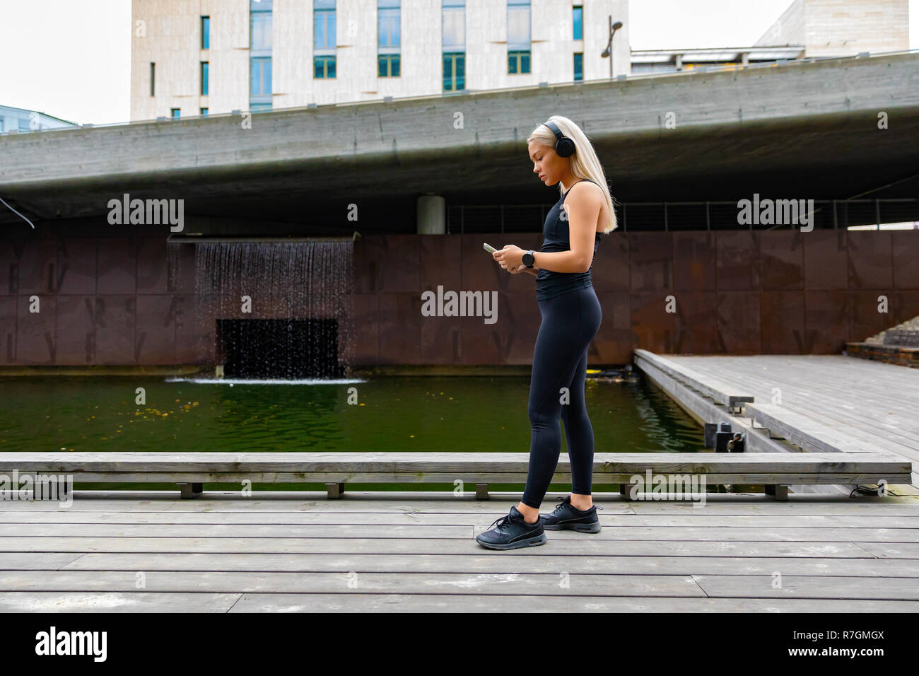 Donna runner avviare la musica sullo smartphone prima di eseguire Foto Stock