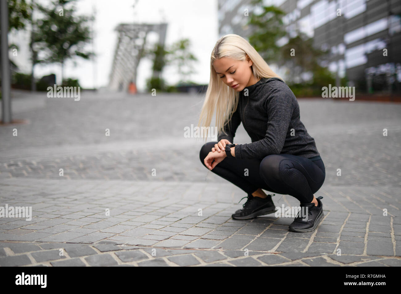 Femmina sportivo Runner utilizzando Smartwatch per vedere la prestazione di funzionamento Foto Stock