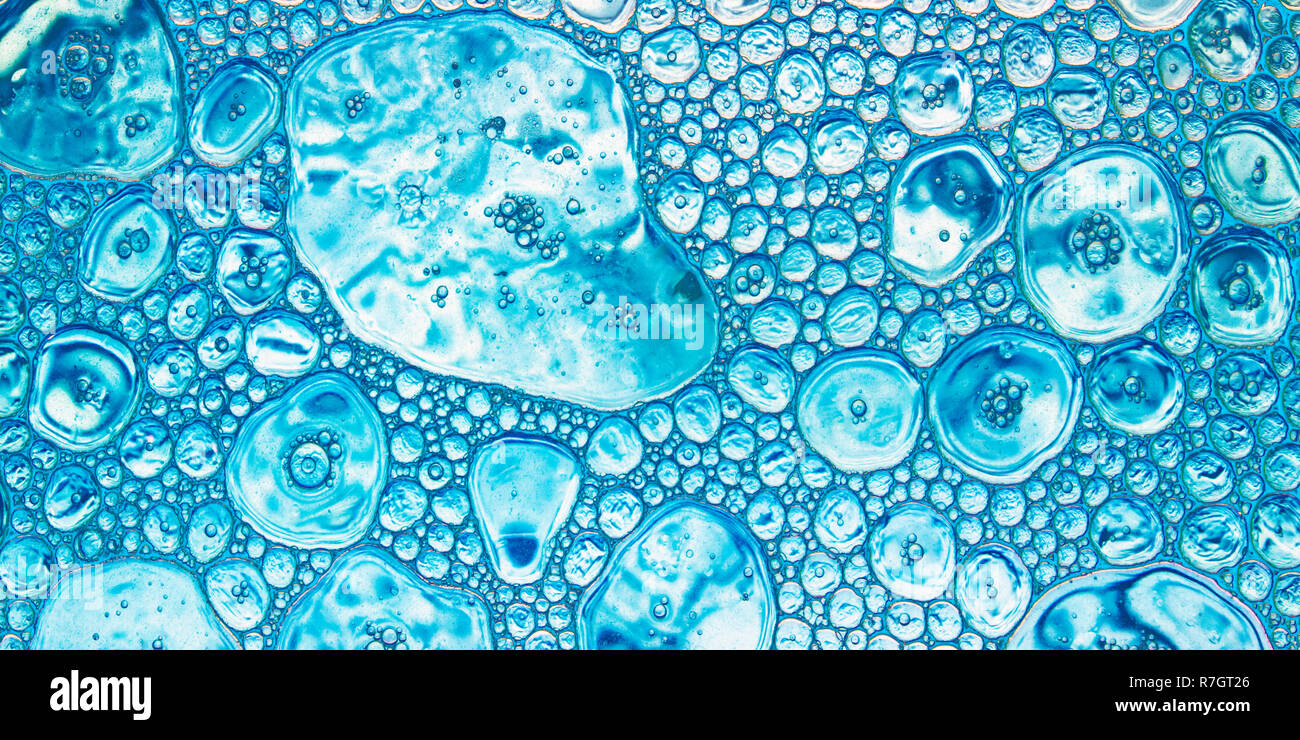 Colore sfondo astratto in toni azzurri, gocce di olio di diverse dimensioni poste su una superficie di acqua Foto Stock