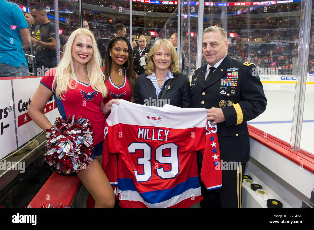 Stati Uniti Capo di Stato Maggiore dell Esercito gen. Mark Milley, destra e sua moglie Hollyanne Milley posano con capitali di Washington hockey cheerleaders durante l esercito apprezzamento notte al Verizon Center Novembre 3, 2016 a Washington, DC. Milley è stato scelto dal presidente Donald Trump su dicembre 8, 2018 a essere il prossimo presidente del Joint Chiefs. Foto Stock